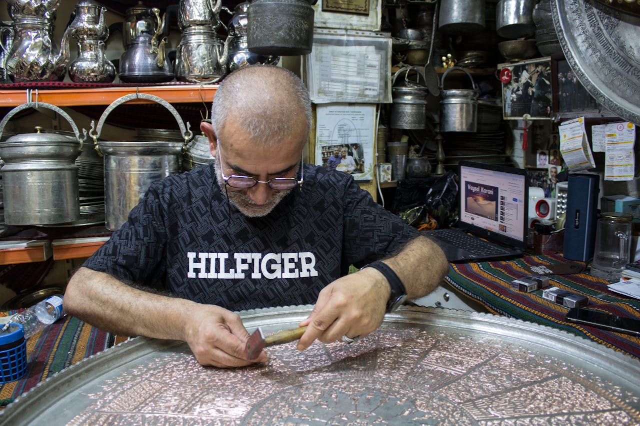 Coppersmith hammering intricate designs into metal, Gaziantep. Authentic Turkish craftsmanship.